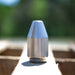 Stainless steel high‑pressure jetting nozzle on wooden surface outdoors, precision‑machined orbital cleaning and cutting tool engineered for hydro‑excavation and industrial surface preparation with rotating zero‑degree water stream performance.