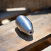 Stainless steel high‑pressure jetting nozzle on wooden surface, precision‑machined conical cleaning and cutting tool engineered for hydro‑excavation and industrial surface preparation using a rotating zero‑degree water stream.