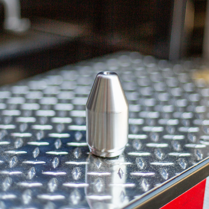 MonroJet F6R stainless steel high‑pressure nozzle on diamond plate, precision orbital jet engineered for rotating zero‑degree water stream performance in industrial surface cleaning, hydro‑excavation, and cutting applications up to 12,000 PSI.