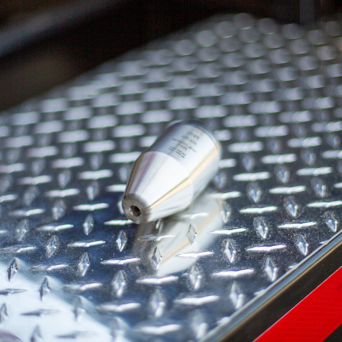 Stainless steel MonroJet F6R orbital nozzle on diamond plate, high‑pressure rotating zero‑degree jet designed for industrial surface cleaning, hydro‑excavation, and precision cutting applications up to 12,000 PSI.