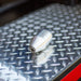 Stainless steel MonroJet F6R orbital nozzle on diamond plate, high‑pressure rotating zero‑degree jet designed for industrial surface cleaning, hydro‑excavation, and precision cutting applications up to 12,000 PSI.