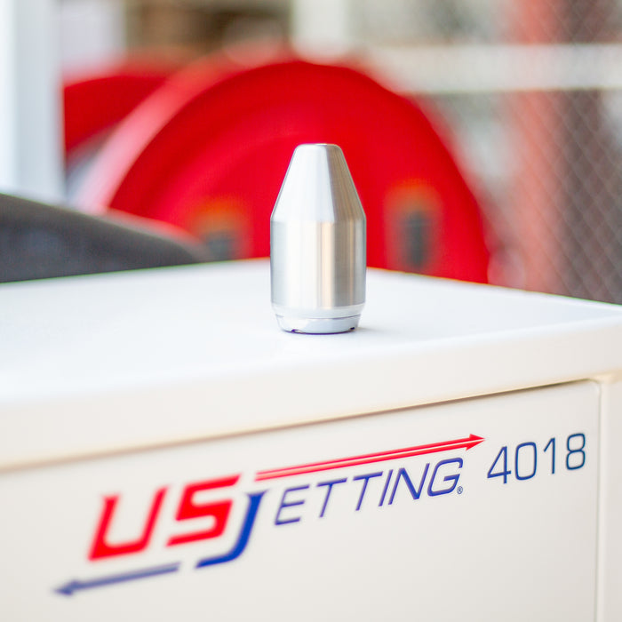 Monro Jet high‑pressure orbital nozzle resting on a US Jetting 4018 unit, stainless steel dump‑gun attachment used for surface cleaning, hydro‑excavating, and cutting with a rotating zero‑degree jet stream rated up to 12,000 PSI.