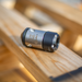 HRV Nozzle - Swiss‑made precision‑engineered metal nozzle with engraved identifiers, featuring a cylindrical body and tapered tip, positioned on a wooden workshop surface; a durable industrial component used in professional mechanical and manufacturing settings.