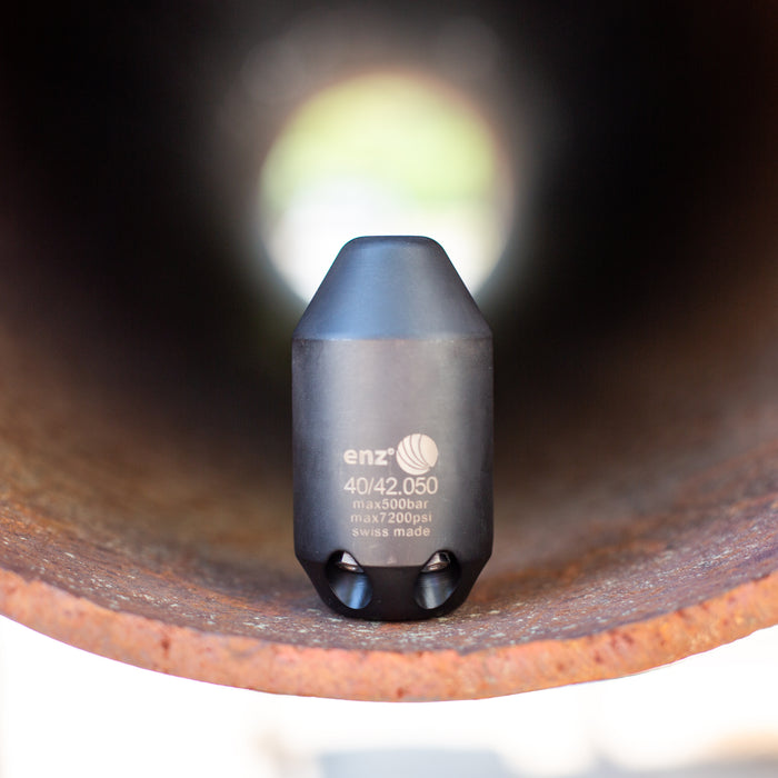 Enz Grenade 40/42.050 high‑pressure sewer jetting nozzle inside rusted pipe, Swiss‑made stainless steel cleaning nozzle rated to 500 bar / 7200 psi for industrial drain and pipe cleaning applications.