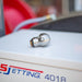 3/8" Warthog Mini Super Spin WT sewer jetting nozzle laying on its side atop a US Jetting 4018 jetter, designed for 3–6 inch pipes and 3/8 inch hoses, ideal for grease, hair, and root removal, operating at 4000 PSI and 12 GPM, featuring 1 forward jet and 2 rear jets for propulsion and full orbital cleaning, controlled rotation delivers non-streak pipe wall cleaning and effective blockage penetration for residential and commercial drain cleaning applications.