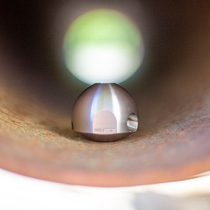 Warthog stainless steel descaling head for 1/2‑inch and 3/4‑inch WH Classic sewer jetting nozzles, shown inside a corroded pipe, featuring dual 105‑degree rear jets and optional plugged front port for maximum scale removal, tuberculation cleaning, and mineral buildup removal during high‑pressure pipe descaling.