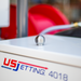 Ball jet high-pressure sewer jetting nozzle mounted on US Jetting 4018 jetter unit, stainless steel multi-port jetter nozzle for drain cleaning and pipe maintenance, professional hydro jetting equipment close-up
