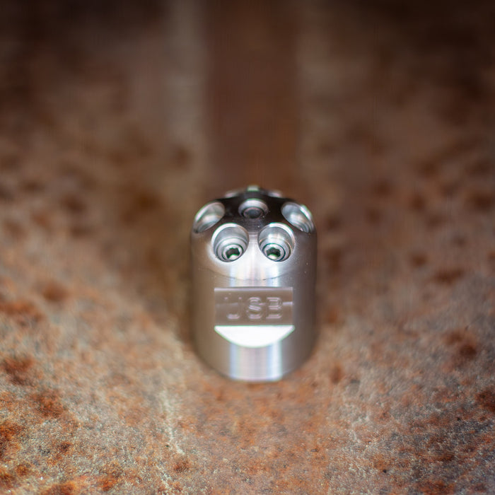 Stainless steel Digger Nozzle for sewer jetting, forward‑jet design with no rear jets to push debris and scale out of small pipes; manually pushed nozzle ideal for short runs under 100 feet during pipe‑lining prep, shown on a textured surface for detailed product display.