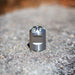 Stainless steel Digger Nozzle for sewer jetting, forward‑jet design with no rear jets to push debris and scale out of small pipes; manually pushed nozzle ideal for short runs under 100 feet during pipe‑lining prep, shown on a rough concrete surface for detailed product display.