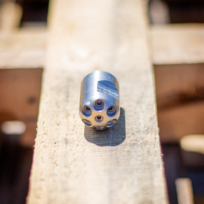 Digger sewer jetting nozzle on wooden surface – stainless steel front-jet drain cleaning nozzle engineered to push debris, sludge, and pipe scale out of small pipes; no rear jets for maximum forward water pressure, ideal for pipe lining prep and short runs under 100 feet requiring manual feed.