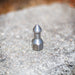 USJ Penetrator 1/2-inch stainless steel sewer jetting nozzle on a rough stone surface, close-up of precision-machined forward jet and six rear jet ports engineered to break through hard blockages like packed debris or ice; high‑pressure 4018 jetter nozzle with adapters available for other hose sizes.
